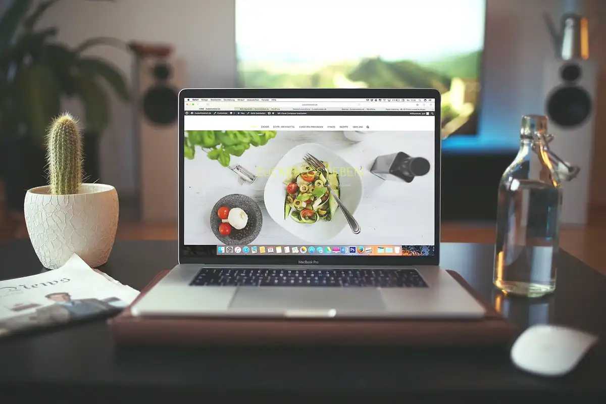 Laptop gri și mouse pe un birou de lucru, cu o pagină de browser deschisă pe ecran