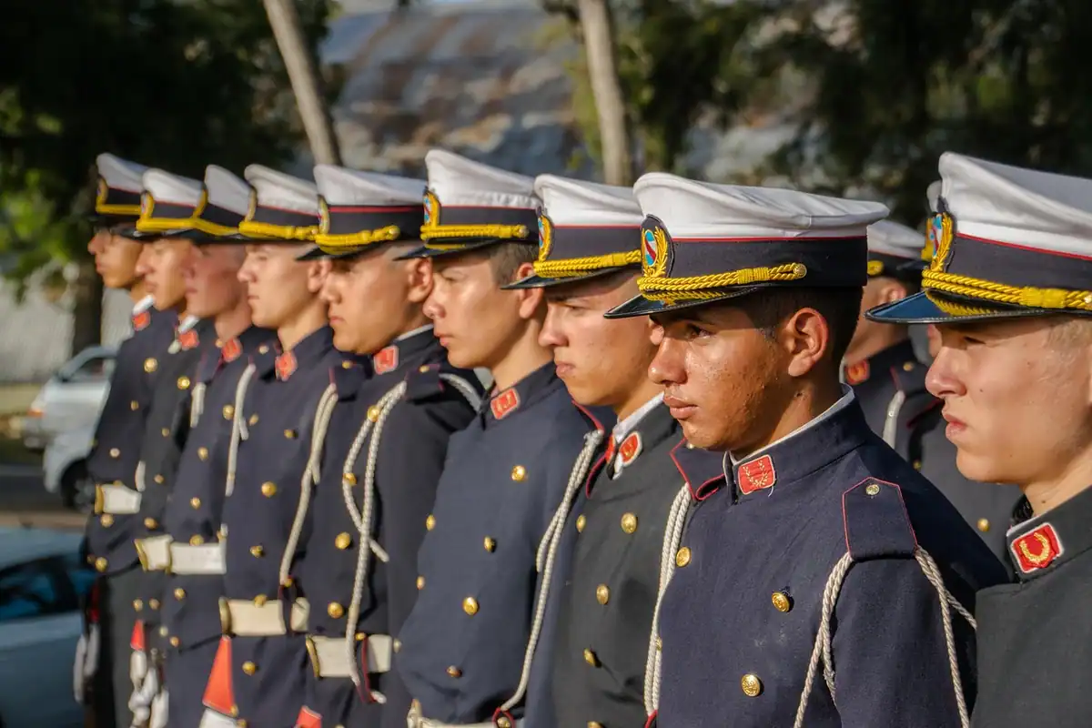 Grup de soldați cu șepci militare, aliniați într-un rând, în formație strânsă