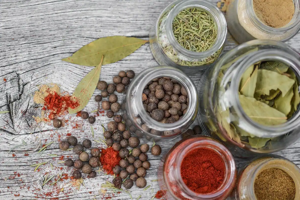 Borcane de sticlă cu mirodenii uscate și ierburi aromatice, aranjate pentru gătit