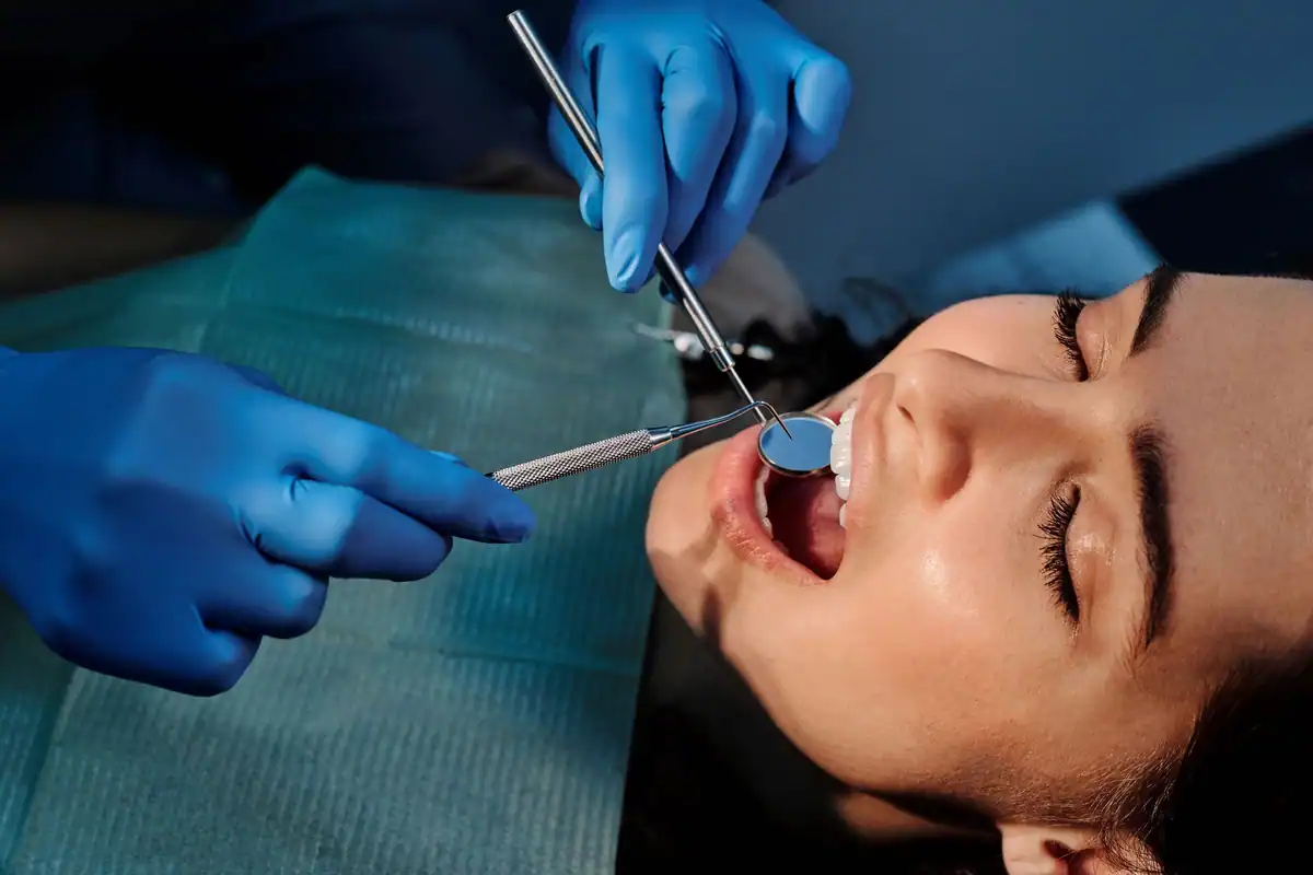 Prim-plan cu instrumente dentare pe o tavă metalică curată și sterilă