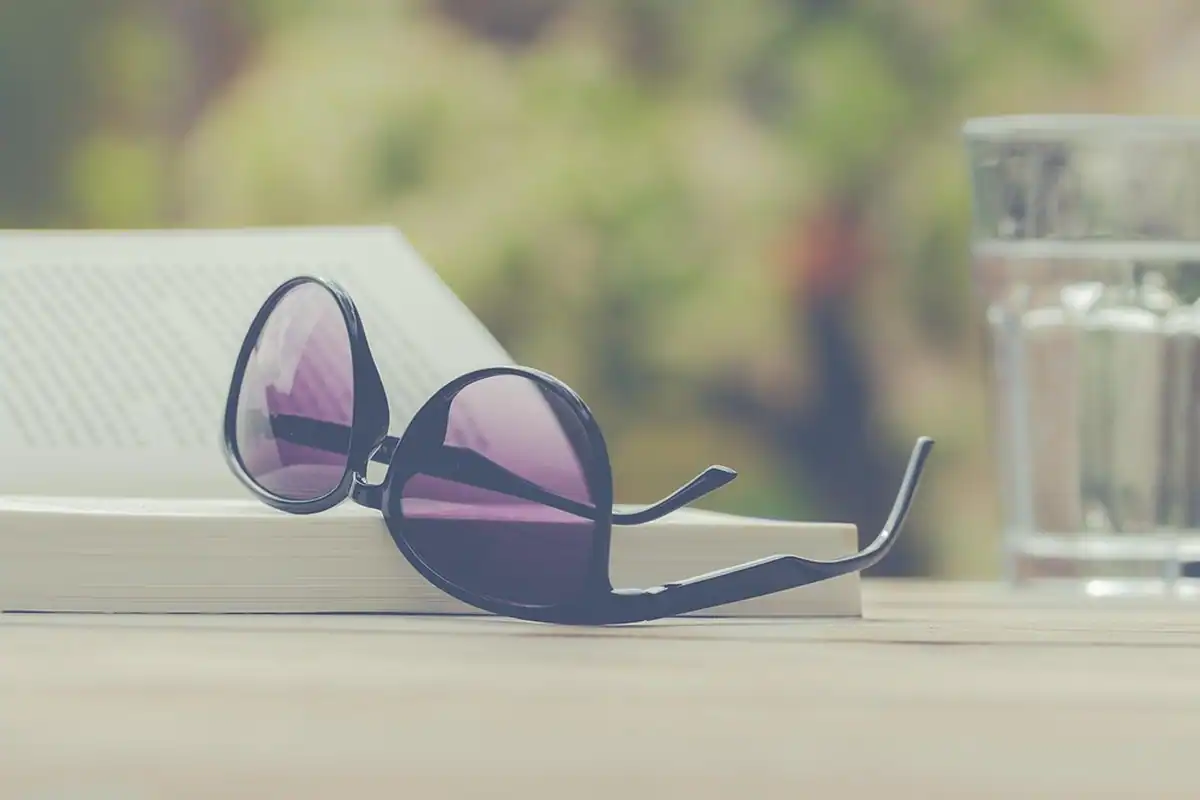 Ochelari de soare și o carte, un moment de relaxare în vacanță, în natură